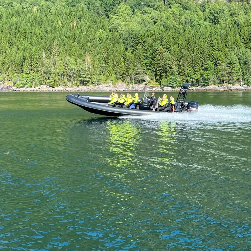 a boat floating along a river next to a body of water