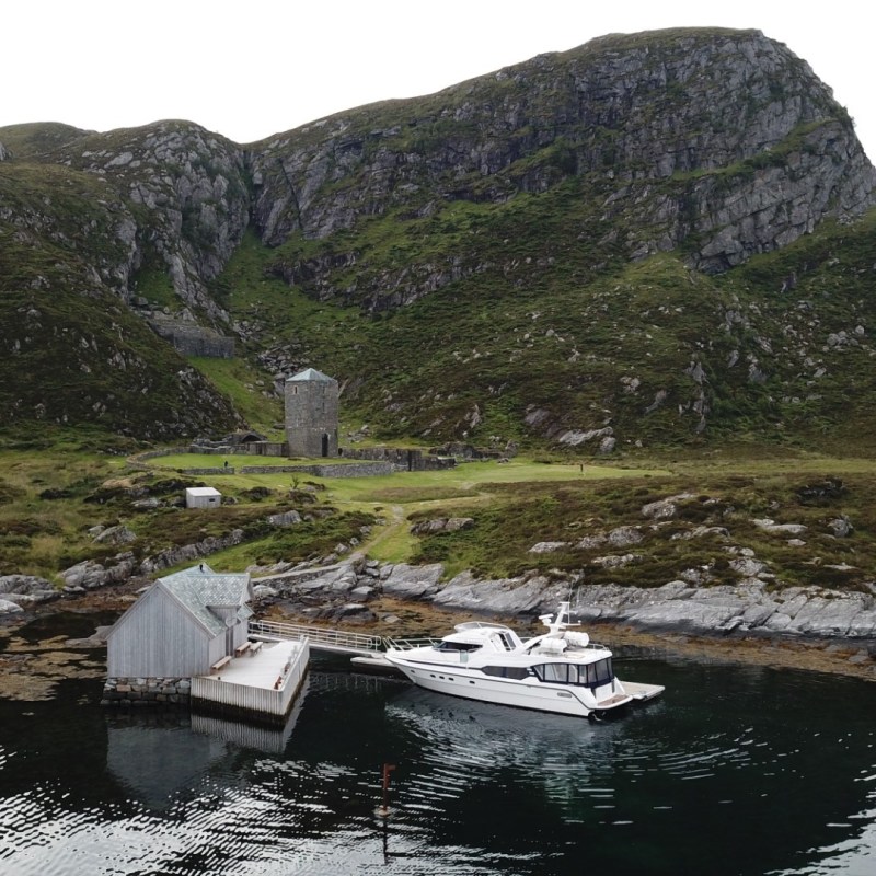 a small boat in a body of water with a mountain in the background